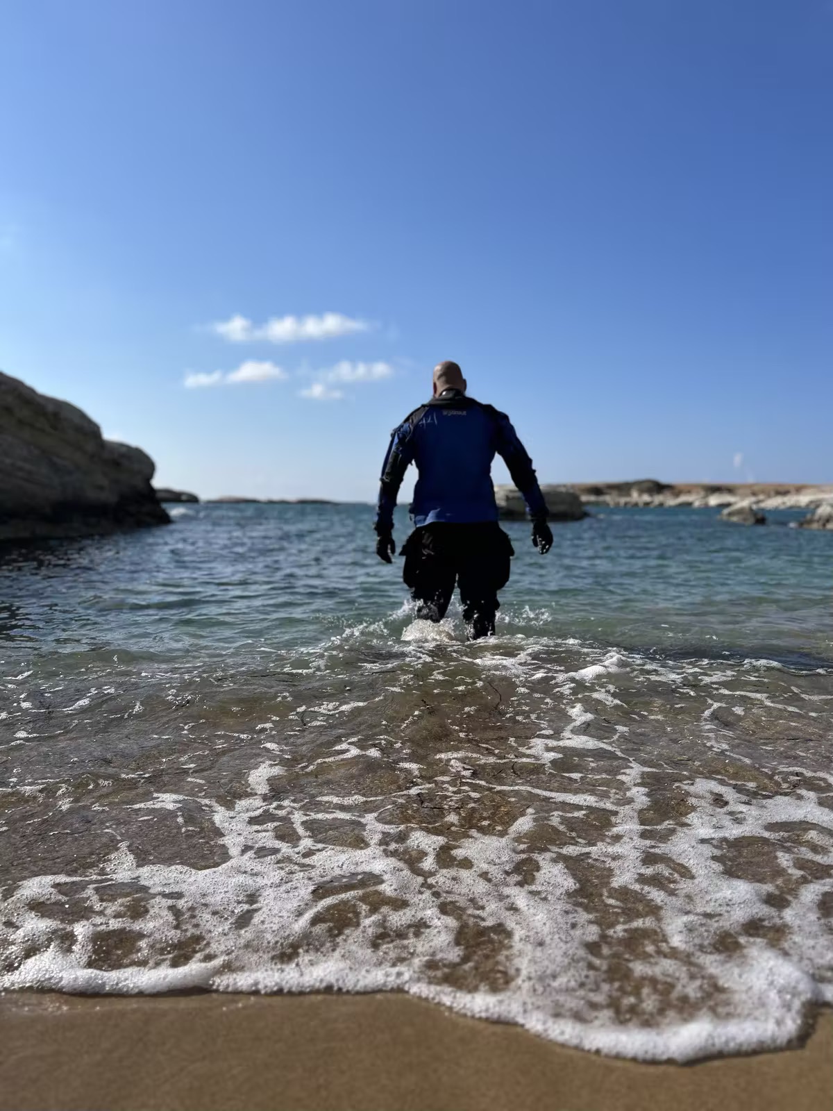 GUE instructor walking into the Mediterranean from a Cyprus shore for a dive