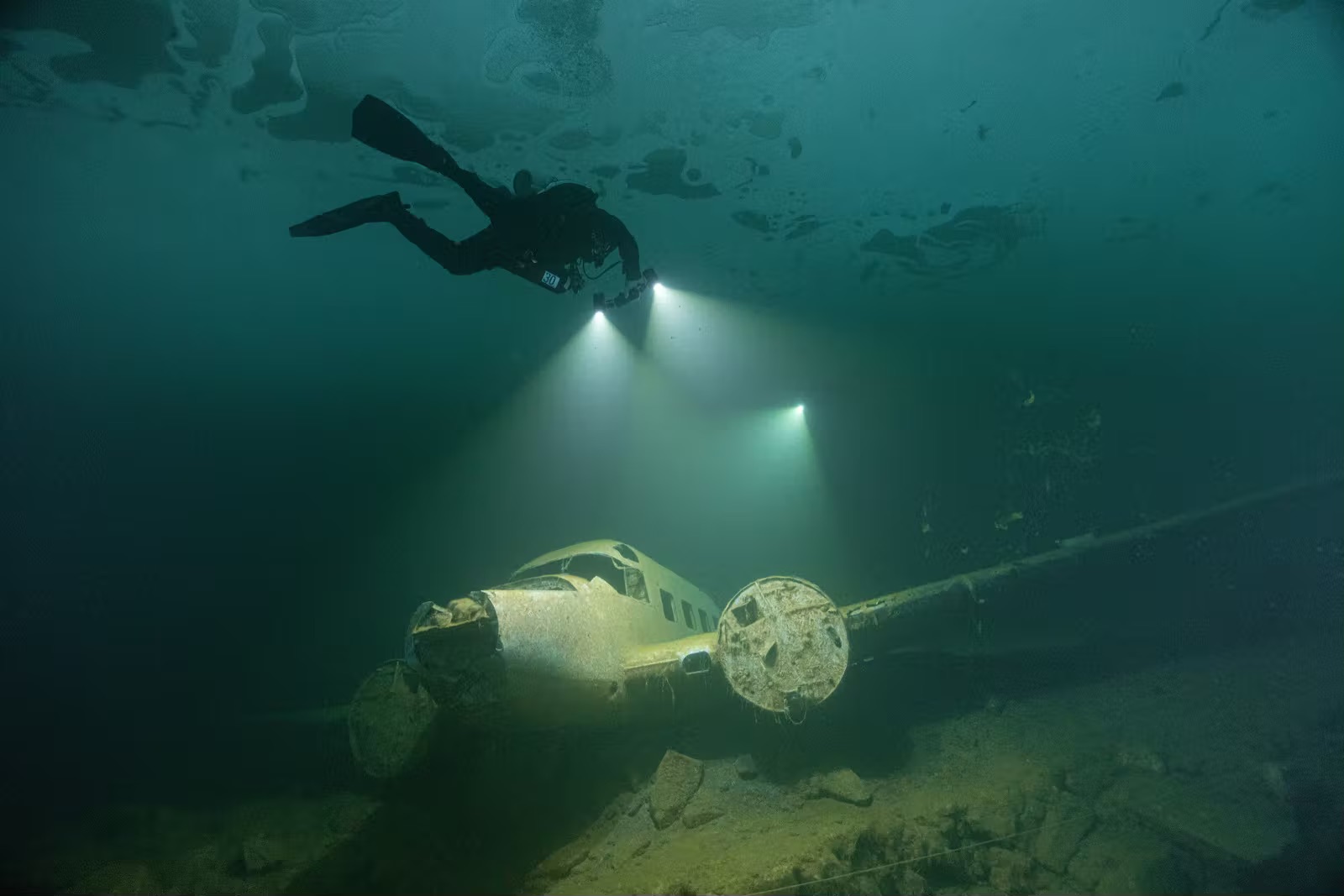 Imad Farhat ice diver hovering above sunken plane wreck at Morrison Quarry Canada